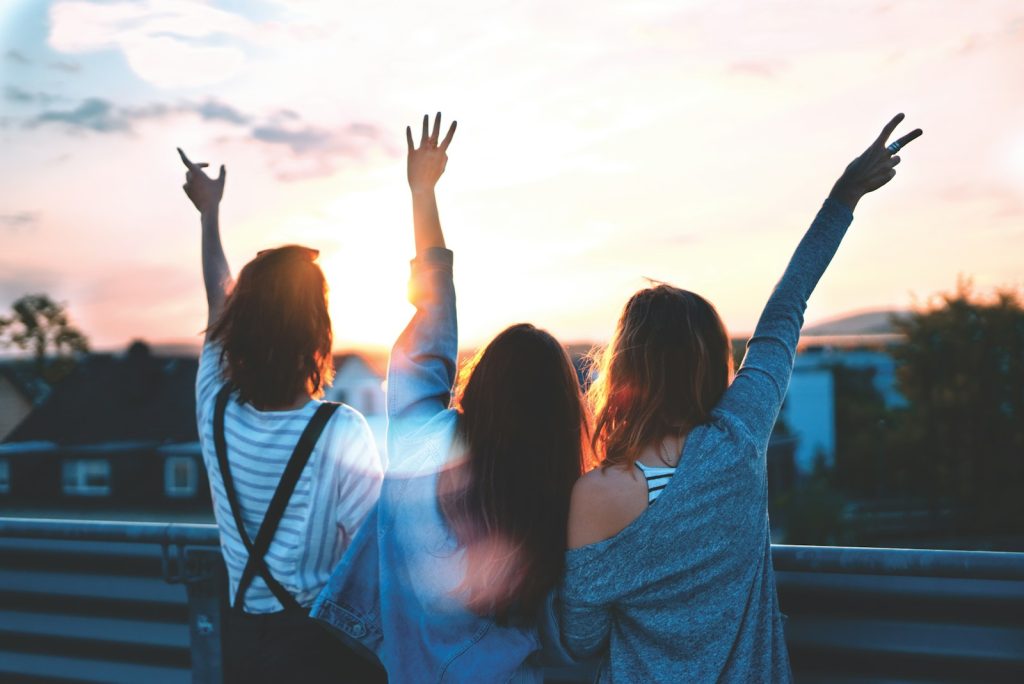 Foto von drei Frauen, die ihre Hände heben 