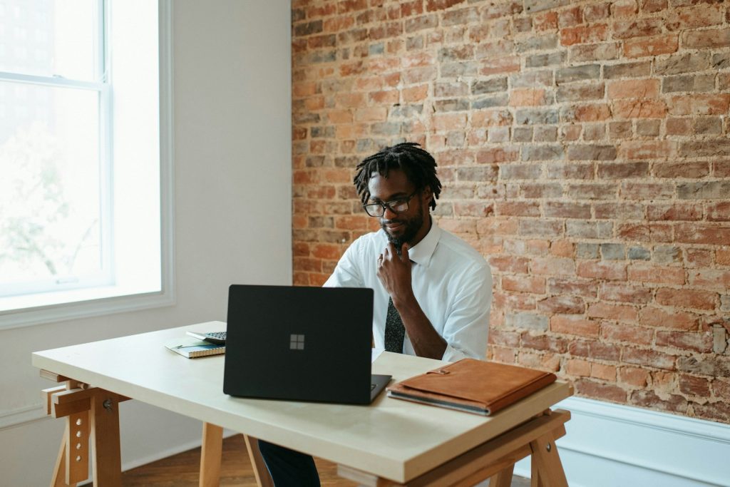 ein Mann sitzt an einem Tisch vor einem Laptop