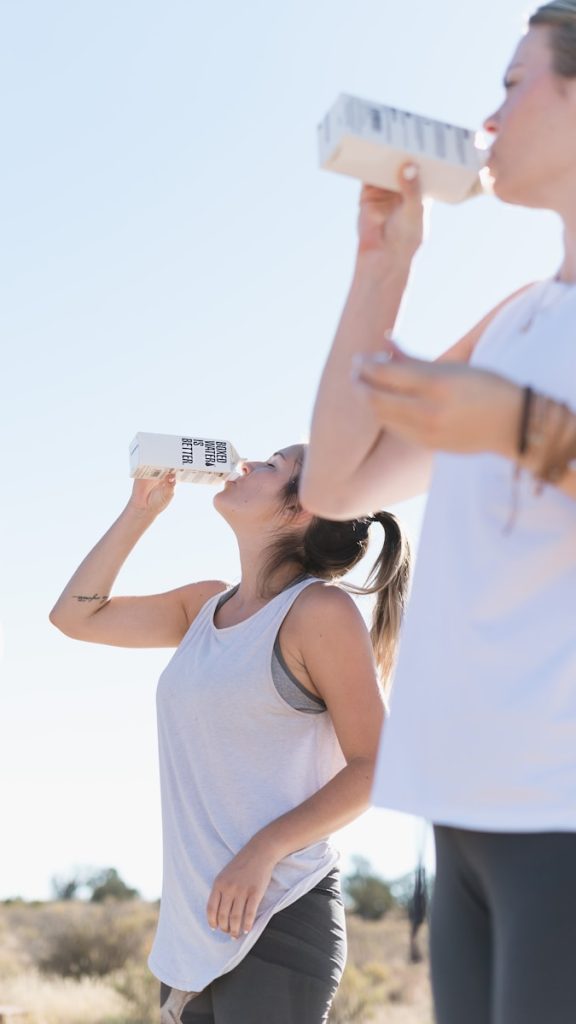 Zwei Frauen, die trainieren und Boxed Water trinken