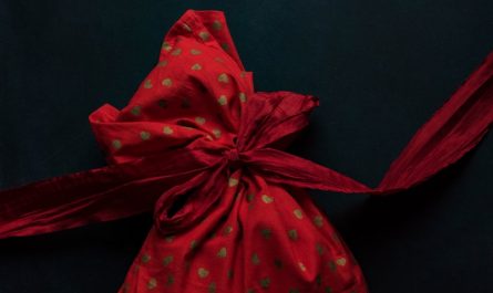 red and gold polka-dot drawstring pack on black surface